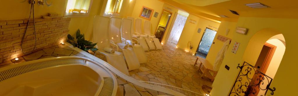 Łazienka z wanną i klatką schodową z poręczą schodową w obiekcie Hotel Dalla Serra w mieście Mezzana