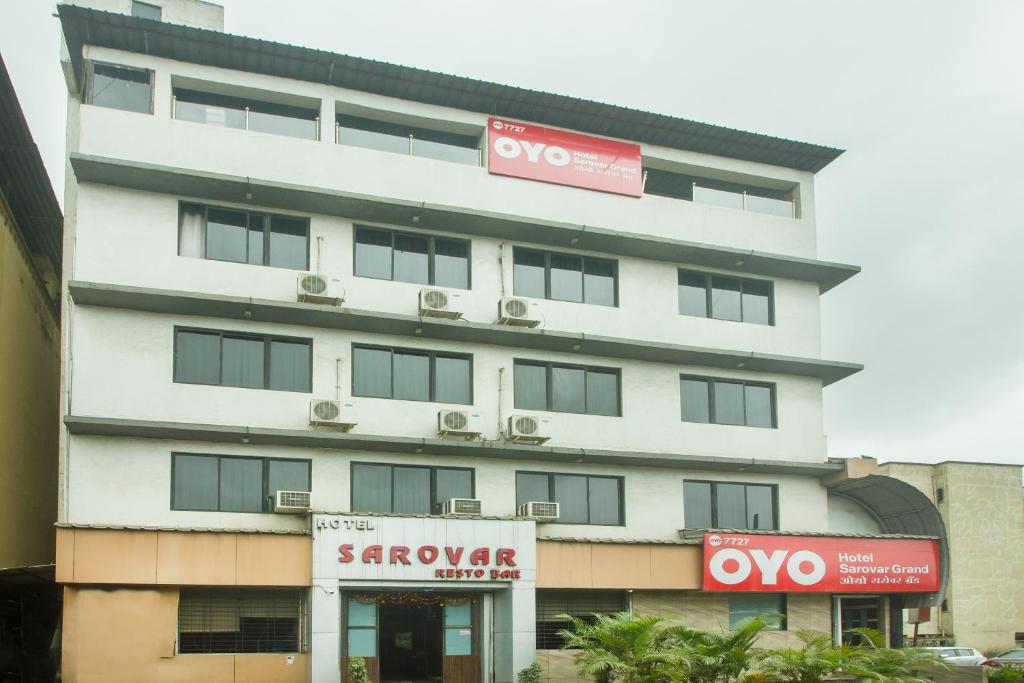 a large white building with a sign in front of it at OYO Hotel Sarovar Grand in Kalamboli