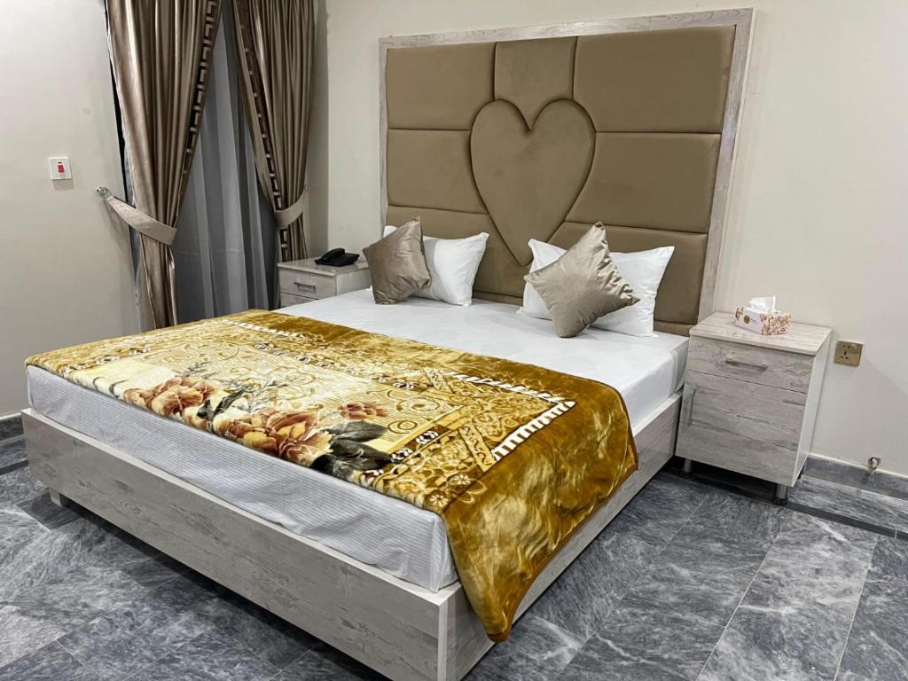 1 dormitorio con 1 cama grande y cabecero grande en Lasani 1 Hotel, en Lahore