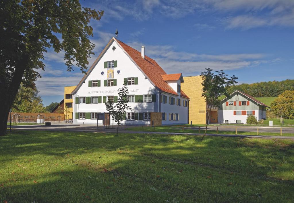 a large white building with a red roof at Hofgut Farny in Kißlegg