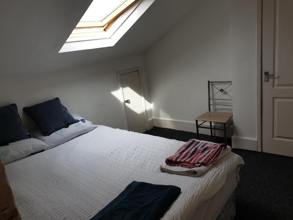 - une chambre avec un grand lit blanc et une lucarne dans l'établissement Townsend Studio/Rooms, à Liverpool