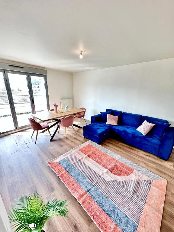 un soggiorno con divano blu e tavolo di Magnificent apart Paris Bagnolet 401 with view a Bagnolet