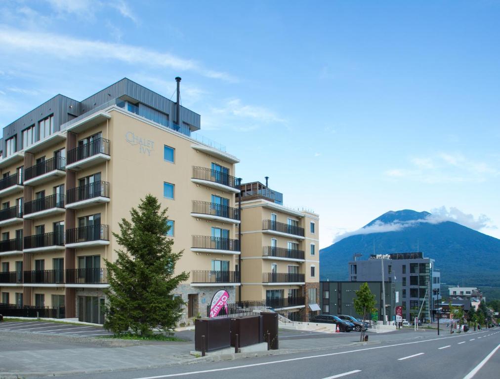 a building on the side of a street with a mountain at Chalet Ivy Hirafu in Niseko