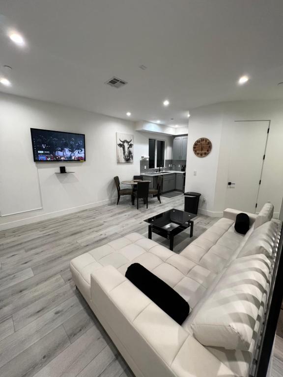 sala de estar con sofá blanco y TV en 1BR Hollywood Townhouse en Los Ángeles