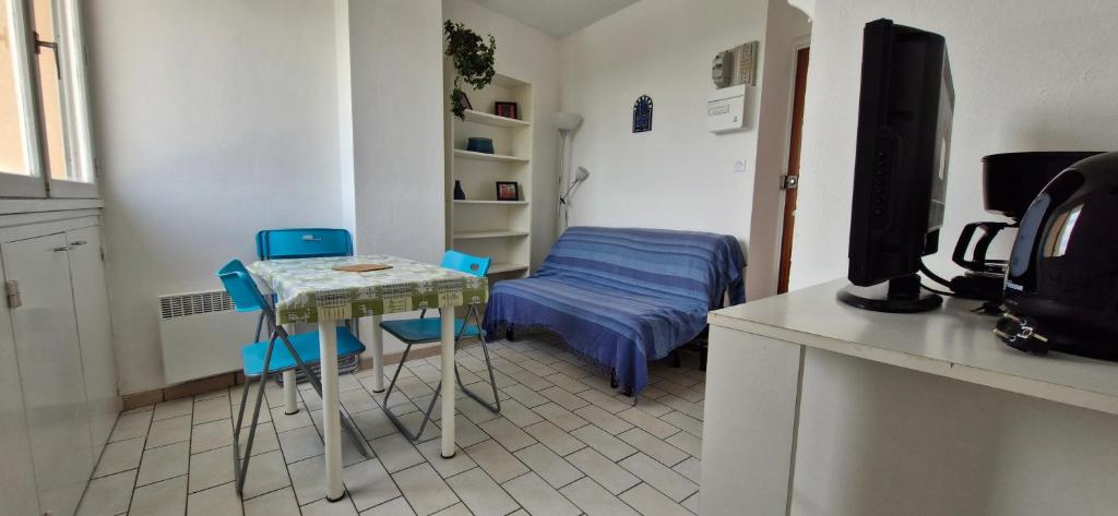 Cette chambre comprend une table, un lit et une télévision. dans l'établissement Studio - Marina 4 - 13 allée des Pinons 8-1, à Saint-Jean-de-Monts