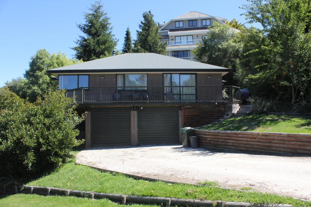 Una casa con balcón y un edificio al fondo. en 45 Alpine Avenue, en Hanmer Springs