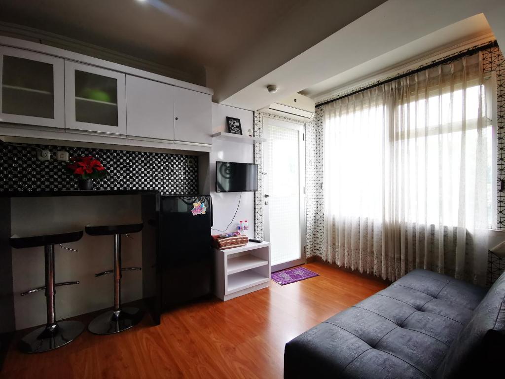 - un salon avec un canapé et une grande fenêtre dans l'établissement Raja Apartemen Jarrdin Type 33, à Bandung