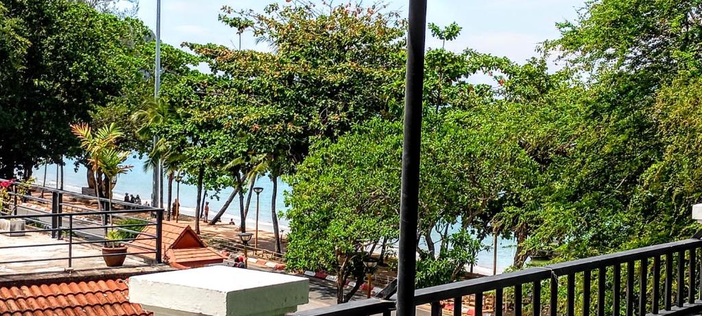 a balcony with a view of the beach and trees at Sea Star House in Ao Nang Beach