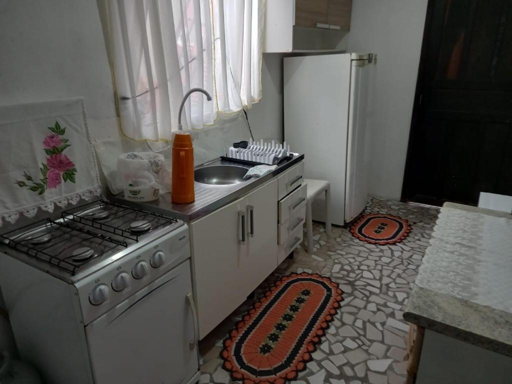 a kitchen with a stove and a sink and a refrigerator at Apartamento1 beto carreiro cozinha compartilhada in Penha