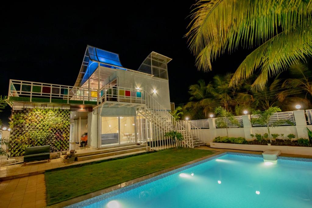 a villa with a swimming pool at night at Abalone 6 BHK Villa by Stayscape in Kīhīm