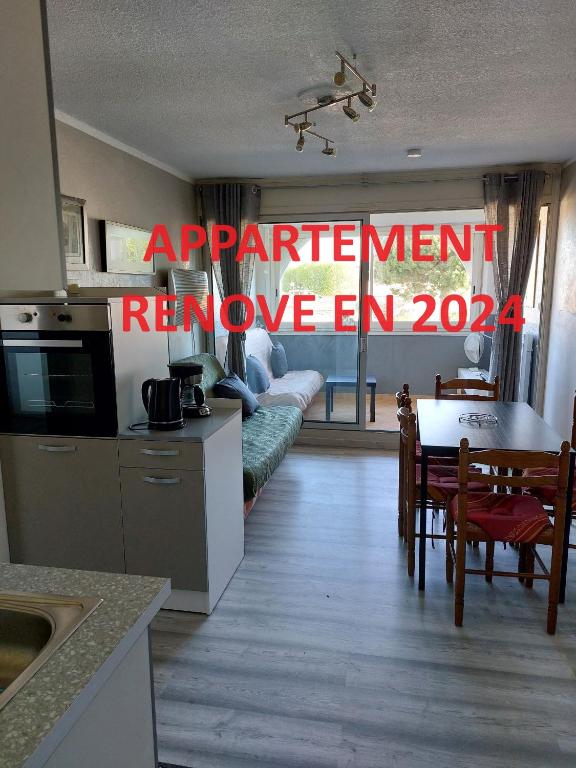 une cuisine et une salle à manger avec un panneau indiquant accord améliorer en dans l'établissement Résidence les Floralies 2 - Avenue de Camargue, au Grau-du-Roi