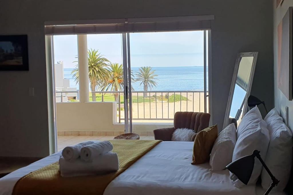 a bedroom with a bed with a view of the ocean at Sunset View 10 @ Langstrand in Langstrand