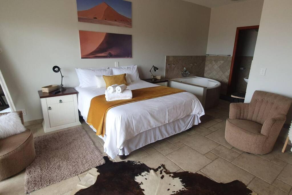 a bedroom with a bed and a couch and a chair at Sunset View 10 @ Langstrand in Langstrand