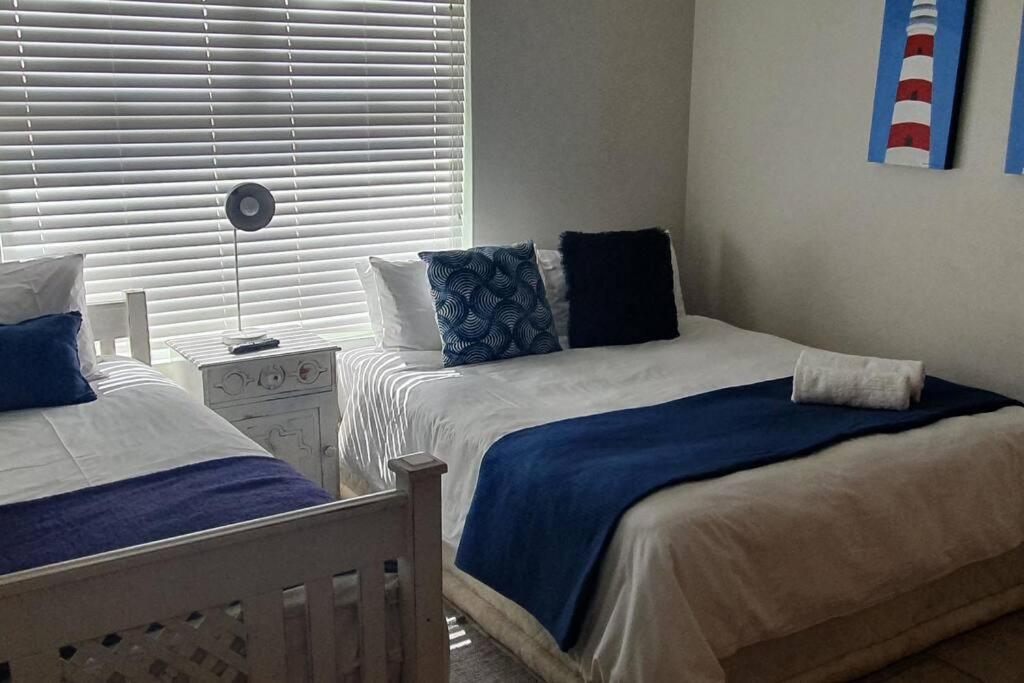 a bedroom with two beds and a window at Sunset View 10 @ Langstrand in Langstrand