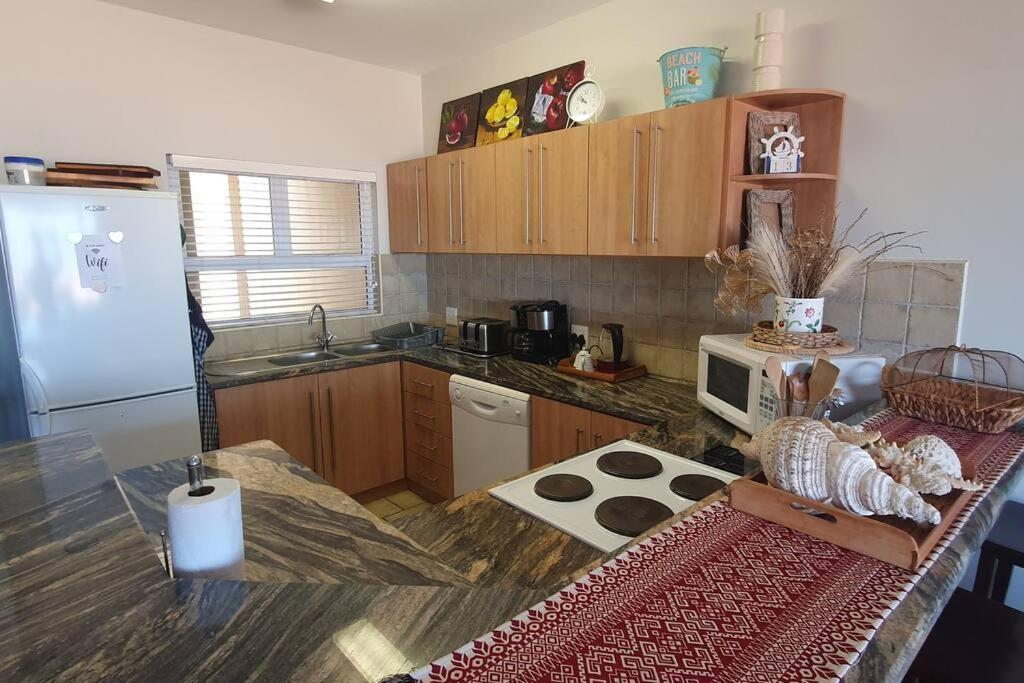 a kitchen with a counter with a refrigerator and a stove at Sunset View 10 @ Langstrand in Langstrand