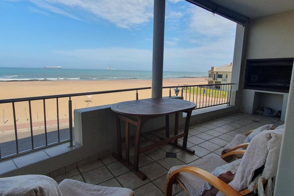 a balcony with a table and a view of the beach at Sunset View 10 @ Langstrand in Langstrand