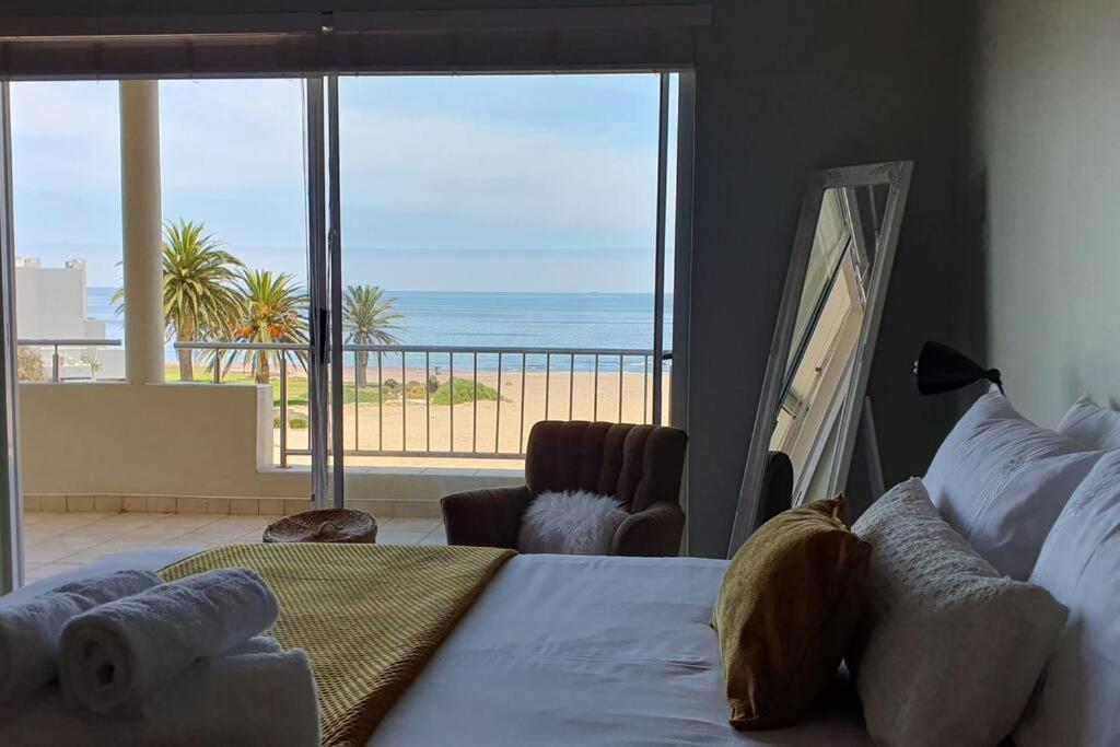 a bedroom with a bed and a view of the ocean at Sunset View 10 @ Langstrand in Langstrand
