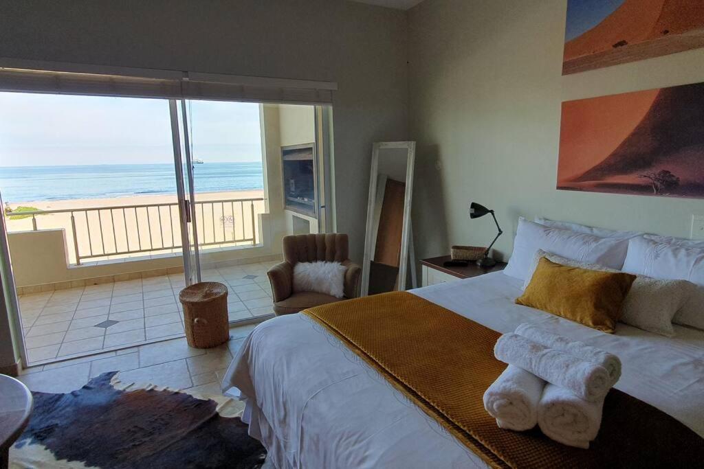 a bedroom with a bed with a view of the ocean at Sunset View 10 @ Langstrand in Langstrand