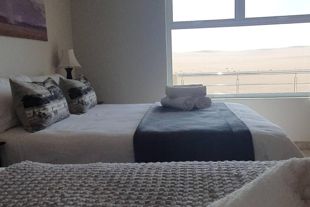 a bedroom with two beds with a view of the ocean at Sunset View 10 @ Langstrand in Langstrand
