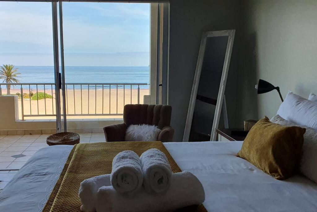 a bedroom with a bed and a view of the ocean at Sunset View 10 @ Langstrand in Langstrand