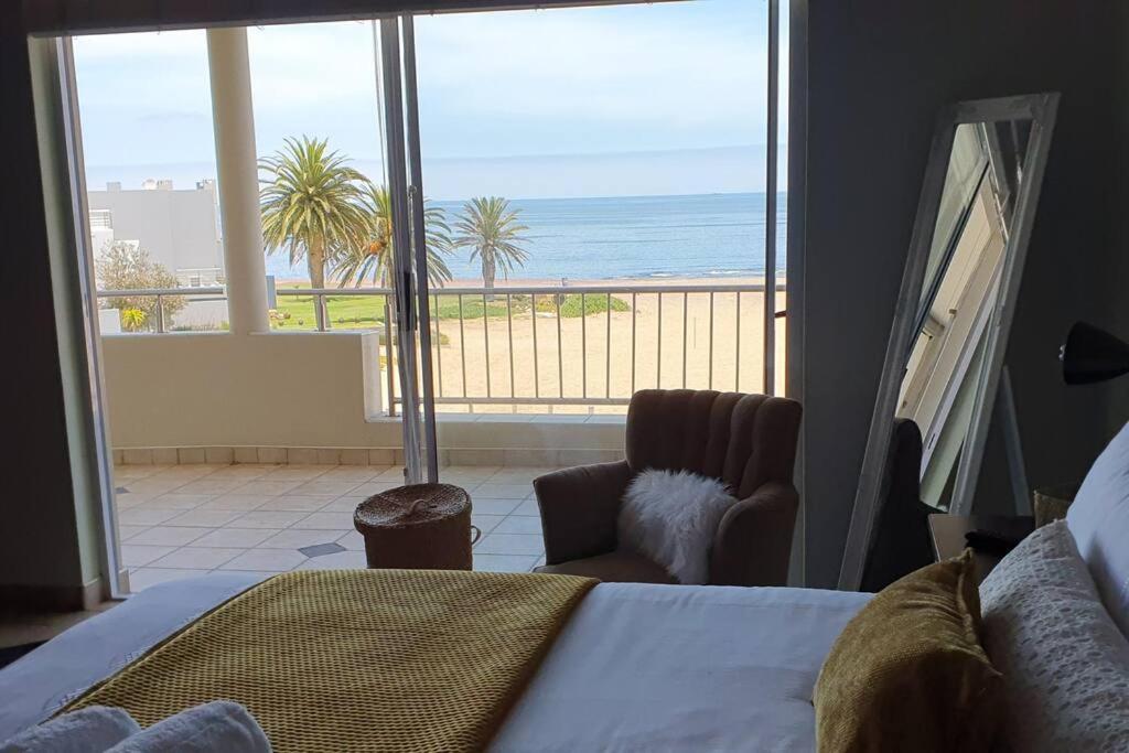 a bedroom with a bed and a view of the ocean at Sunset View 10 @ Langstrand in Langstrand