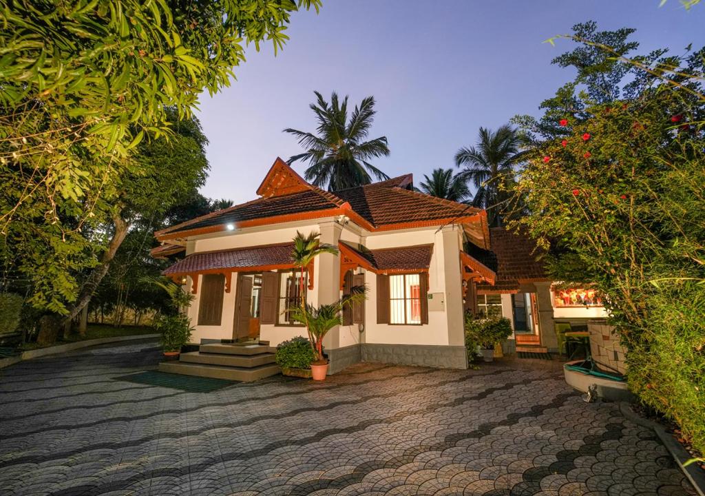 a small house with a driveway in front of it at Pop Tavern Private Pool Villa Kovalam by VOYE HOMES in Kovalam