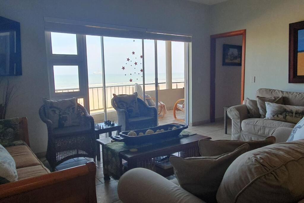 a living room with couches and a view of the ocean at Sunset View 10 @ Langstrand in Langstrand