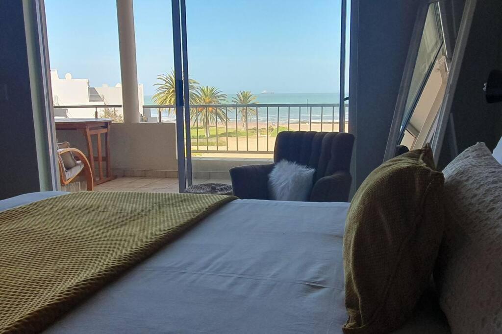 a bedroom with a bed and a view of the ocean at Sunset View 10 @ Langstrand in Langstrand