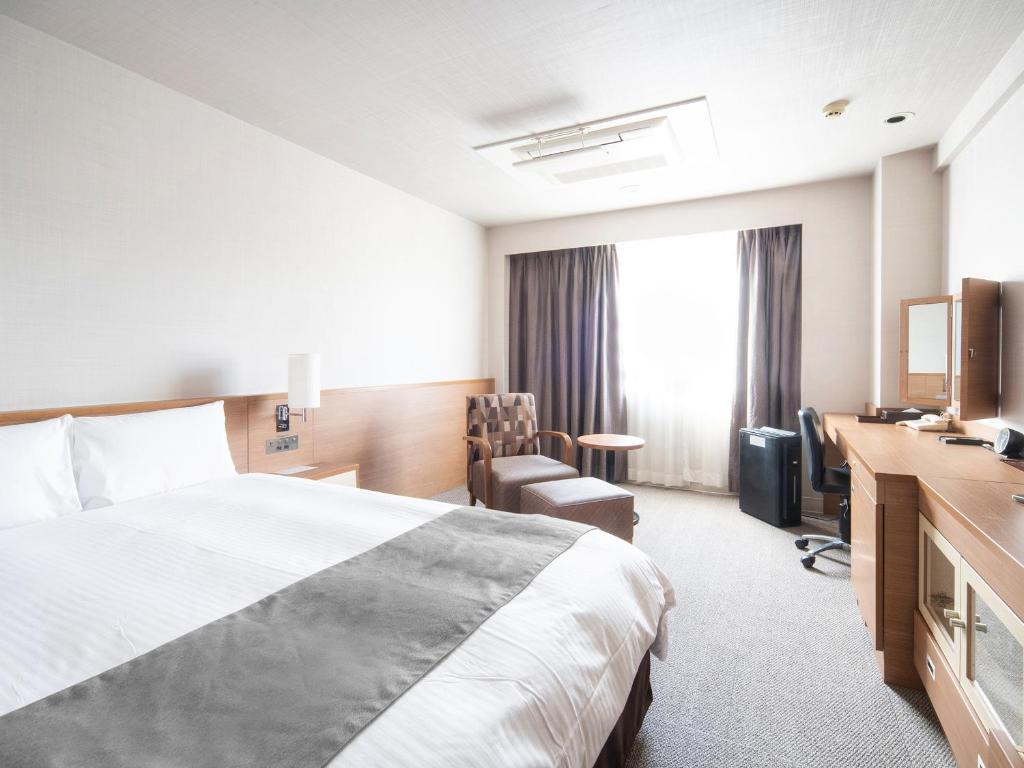 Postel nebo postele na pokoji v ubytování Vessel Inn Fukuyama Station