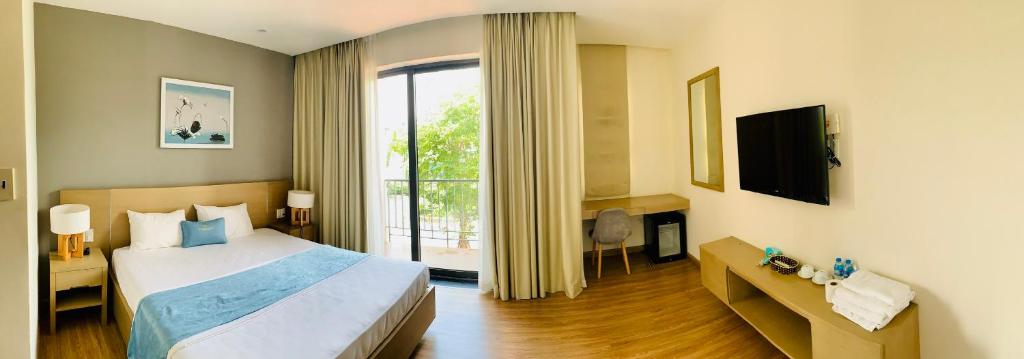 a hotel room with a bed and a window at Vila Lotus Hạ Long in Ha Long