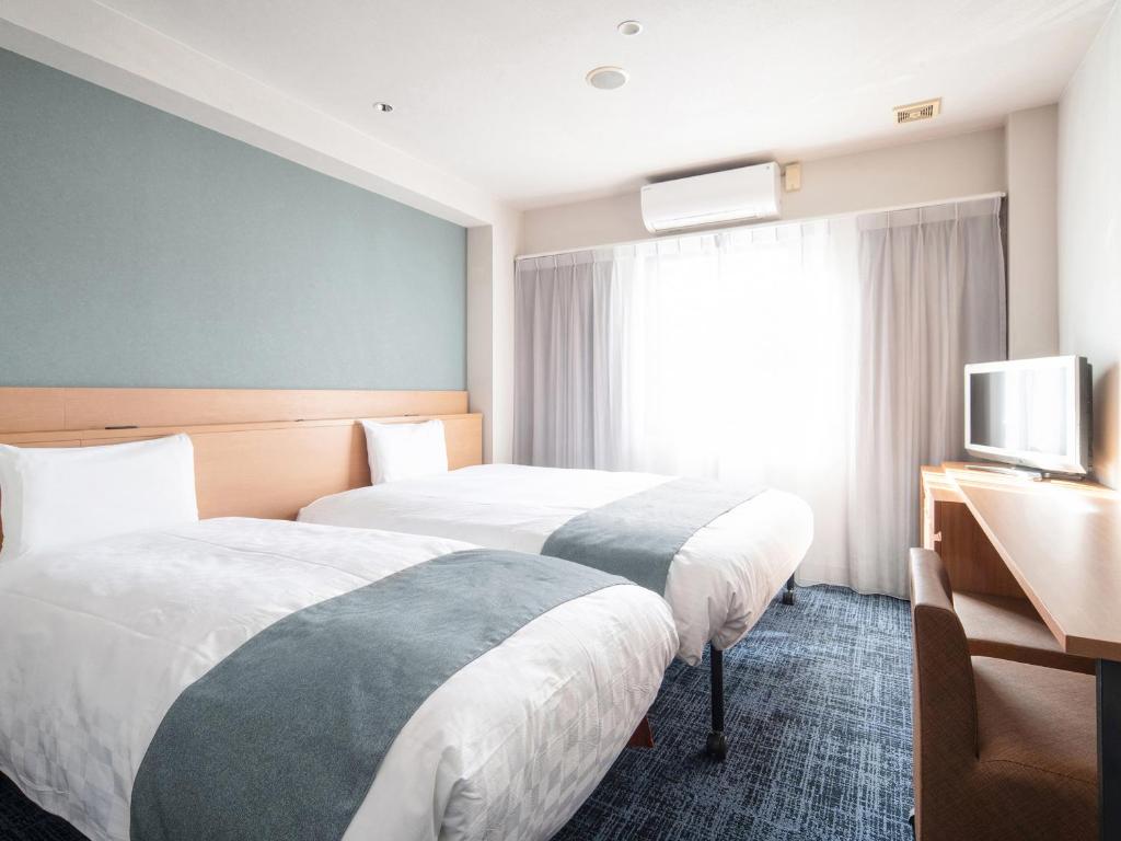 倉敷市にあるベッセルホテル倉敷のベッド2台とテレビが備わるホテルルームです。