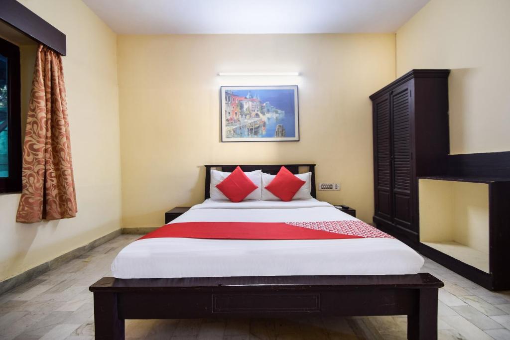 1 dormitorio con 1 cama grande con almohadas rojas en OYO 24408 Nirmala Guest House en Jodhpur