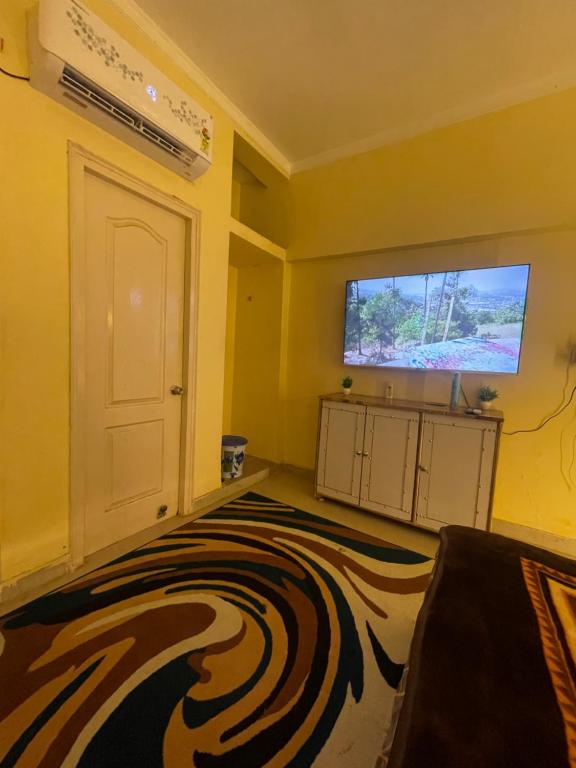 Habitación amarilla con alfombra de cebra y puerta blanca en Mannat Manzil en Lucknow