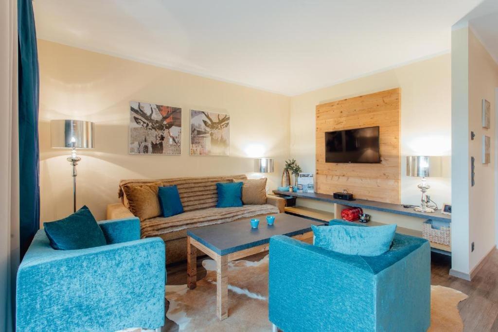 a living room with a couch and two blue chairs at Residenz MAX by MoniCare in Seefeld in Tirol