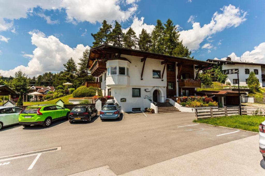 a parking lot with cars parked in front of a building at Appartement Lucia (Haus Almidyll) by MoniCare in Seefeld in Tirol