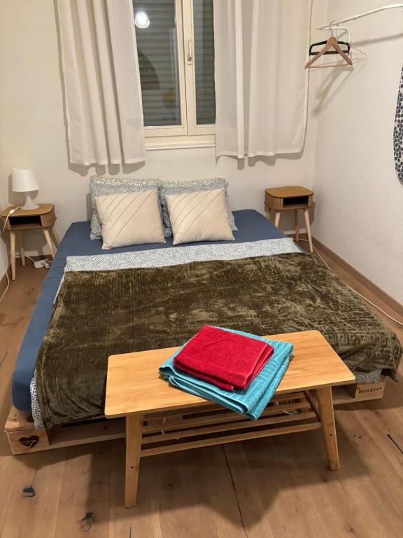 ein Bett mit einem Holztisch mit Handtüchern darauf in der Unterkunft Appartment 15min from Zürich by train at the Lake in Oberrieden