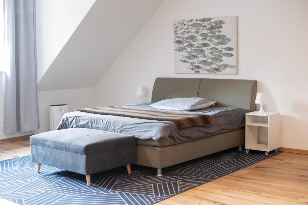 a bedroom with a bed and a ottoman at Apartment mit Parkblick & Massagestuhl in Leipzig