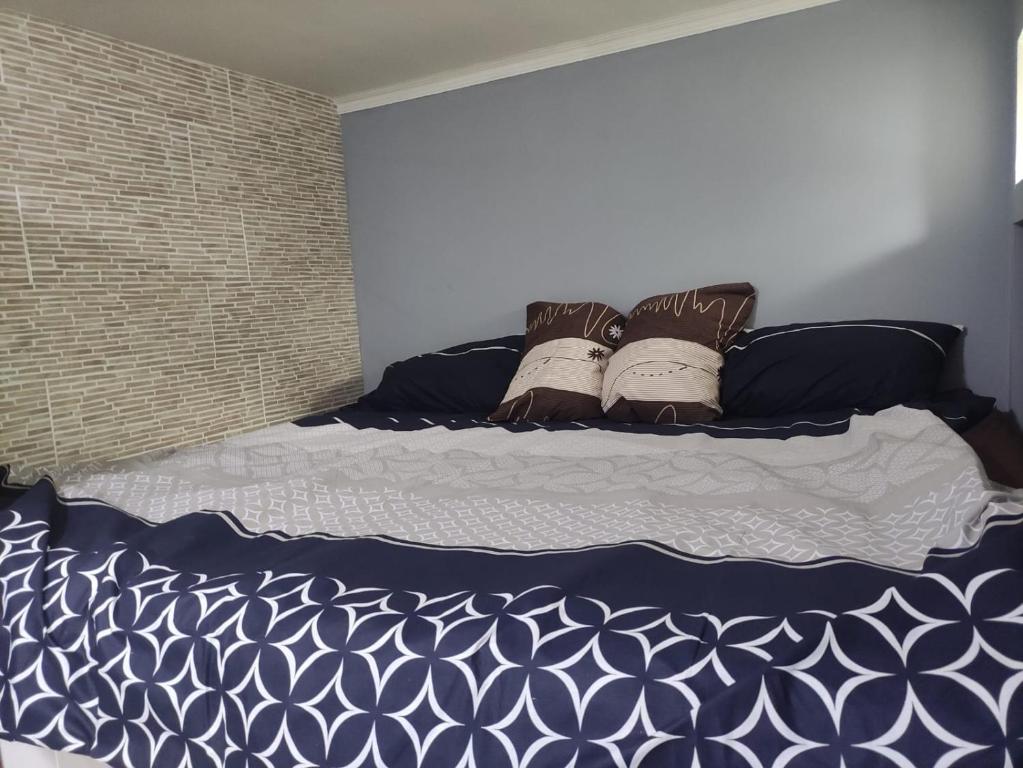 Un dormitorio con una cama con sábanas y almohadas azules y blancas en Small Home, en Chişinău