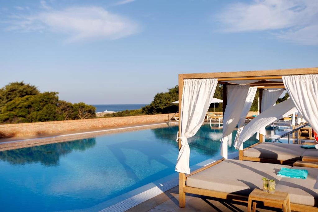 a swimming pool with two lounge chairs next to it at Iberostar Selection Andalucia Playa in Chiclana de la Frontera