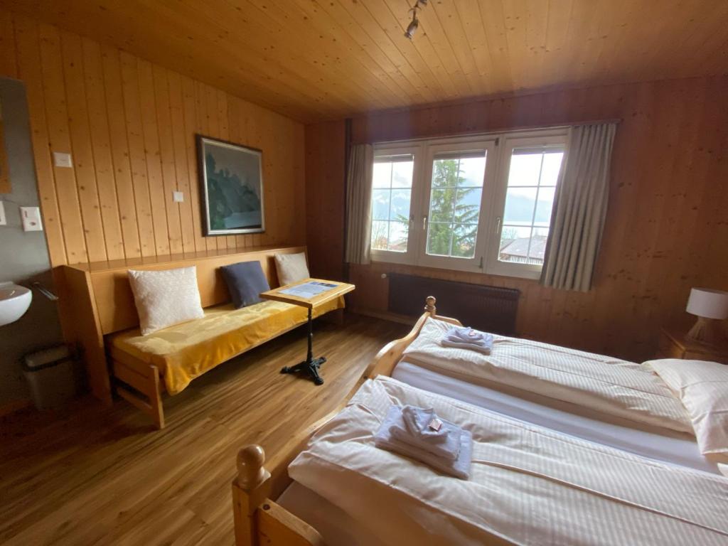 1 dormitorio con 2 camas y sofá en B & B Brienz, en Brienz