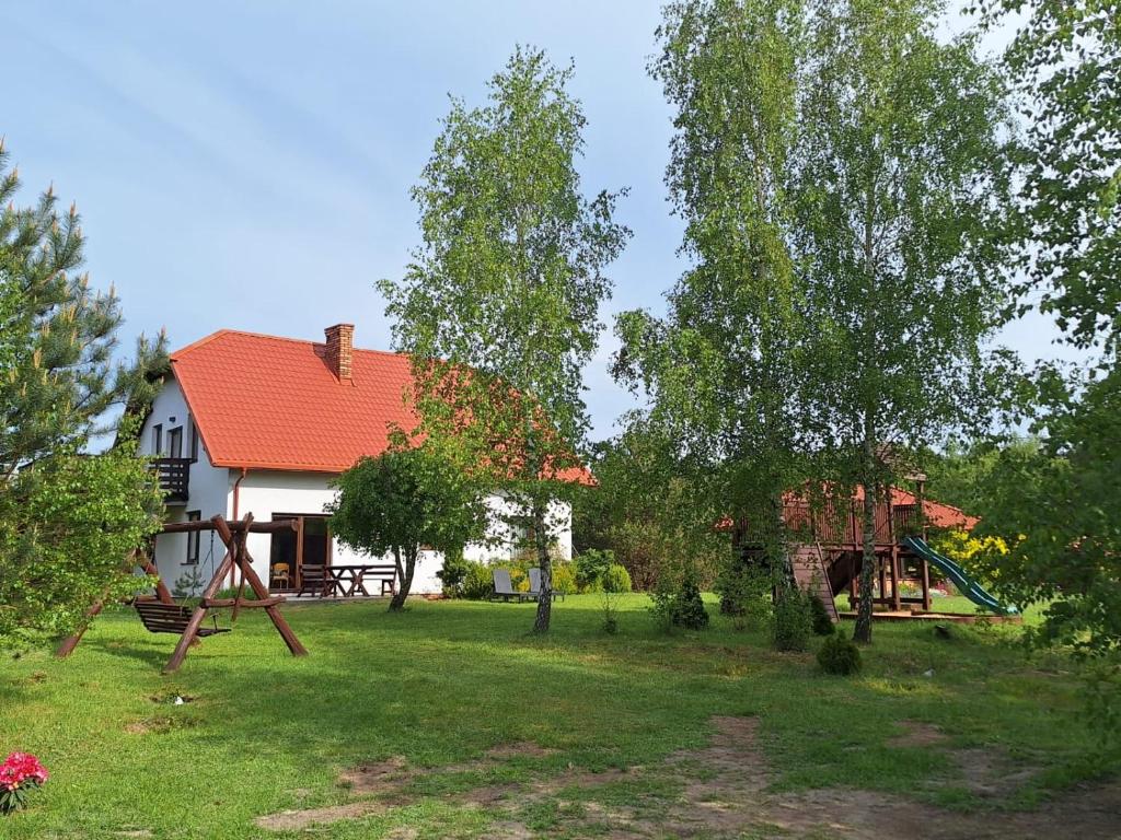 een huis met een speeltuin in de tuin bij Borowy Zakątek in Stara Kiszewa
