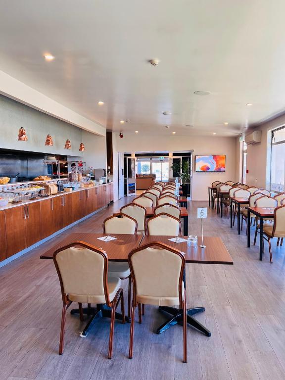 a row of tables and chairs in a restaurant at Airport Gateway Hotel in Auckland