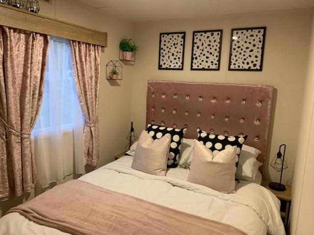 um quarto com uma cama com almofadas e uma janela em The Wardens Retreat - Tattershall Lakes Country Park em Tattershall