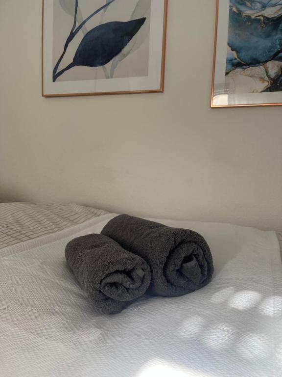 a pair of towels sitting on top of a bed at Cozy Airport Apartment in Kelsterbach