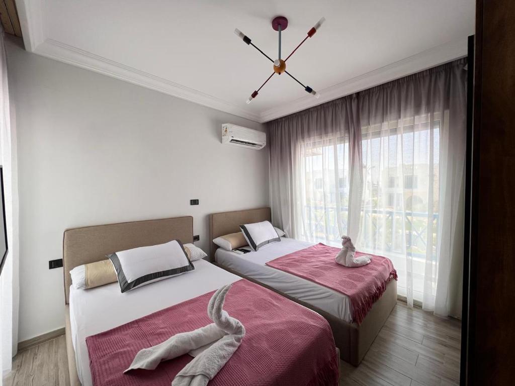 um quarto com 2 camas e uma janela em Twin house 4 master Bedrooms premium mountain view Ras Elhekma em Ras Elhekma