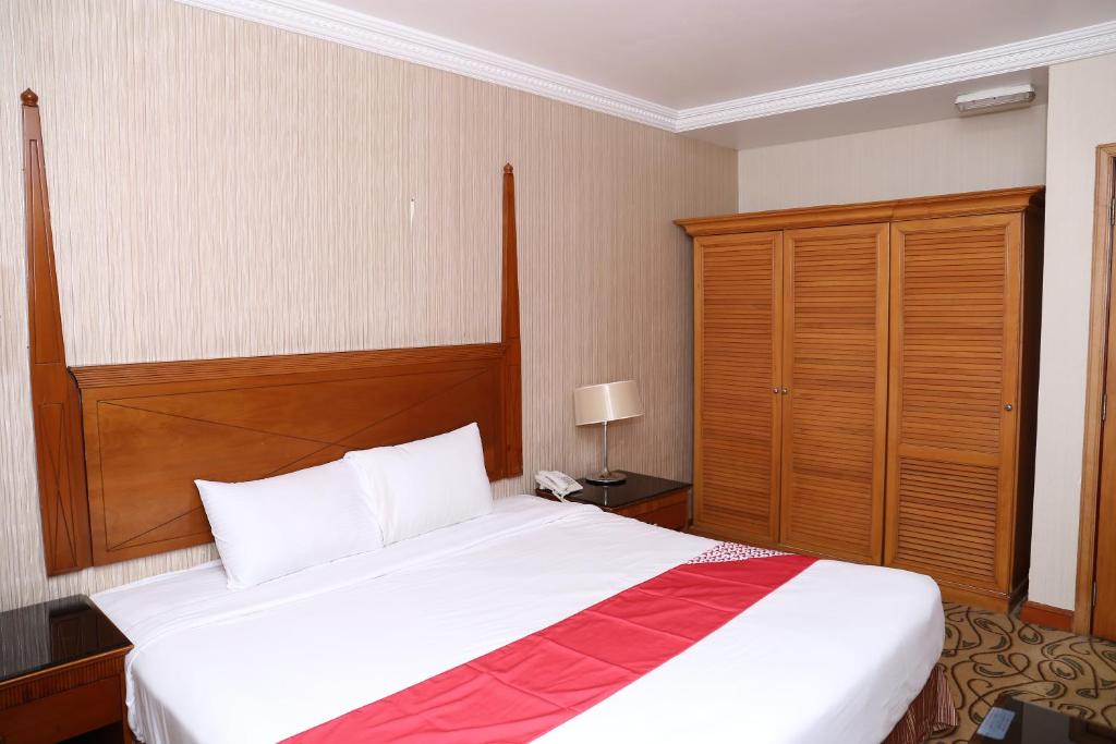 a bedroom with a large bed with a wooden headboard at City Plaza Hotel in Fujairah