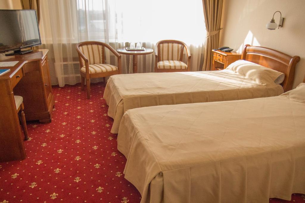 a hotel room with two beds and a television at Hotel Traian in Brăila