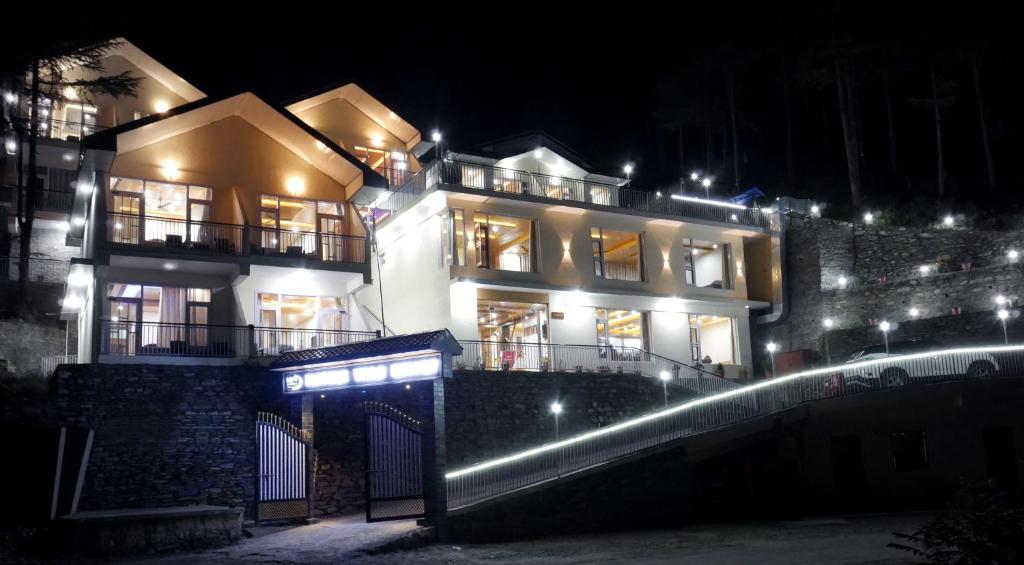 una casa grande con luces encendidas por la noche en Nature Villa Resort, Chail, en Chail