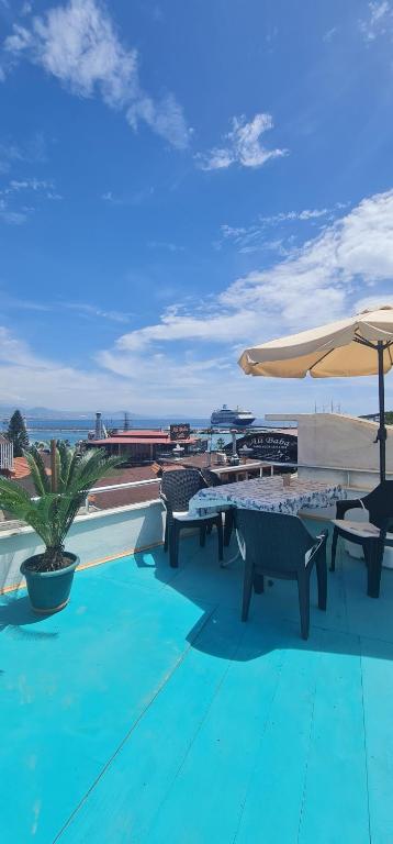 un patio con mesas, sillas y una sombrilla en sea and mountain view roof terrace central, en Alanya