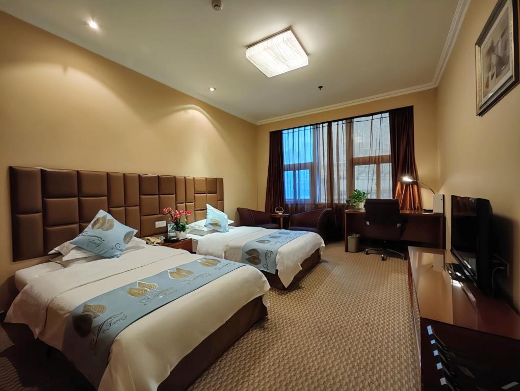 Chongqing Milky Way Hotel في تشونغتشينغ: غرفه فندقيه سريرين وتلفزيون